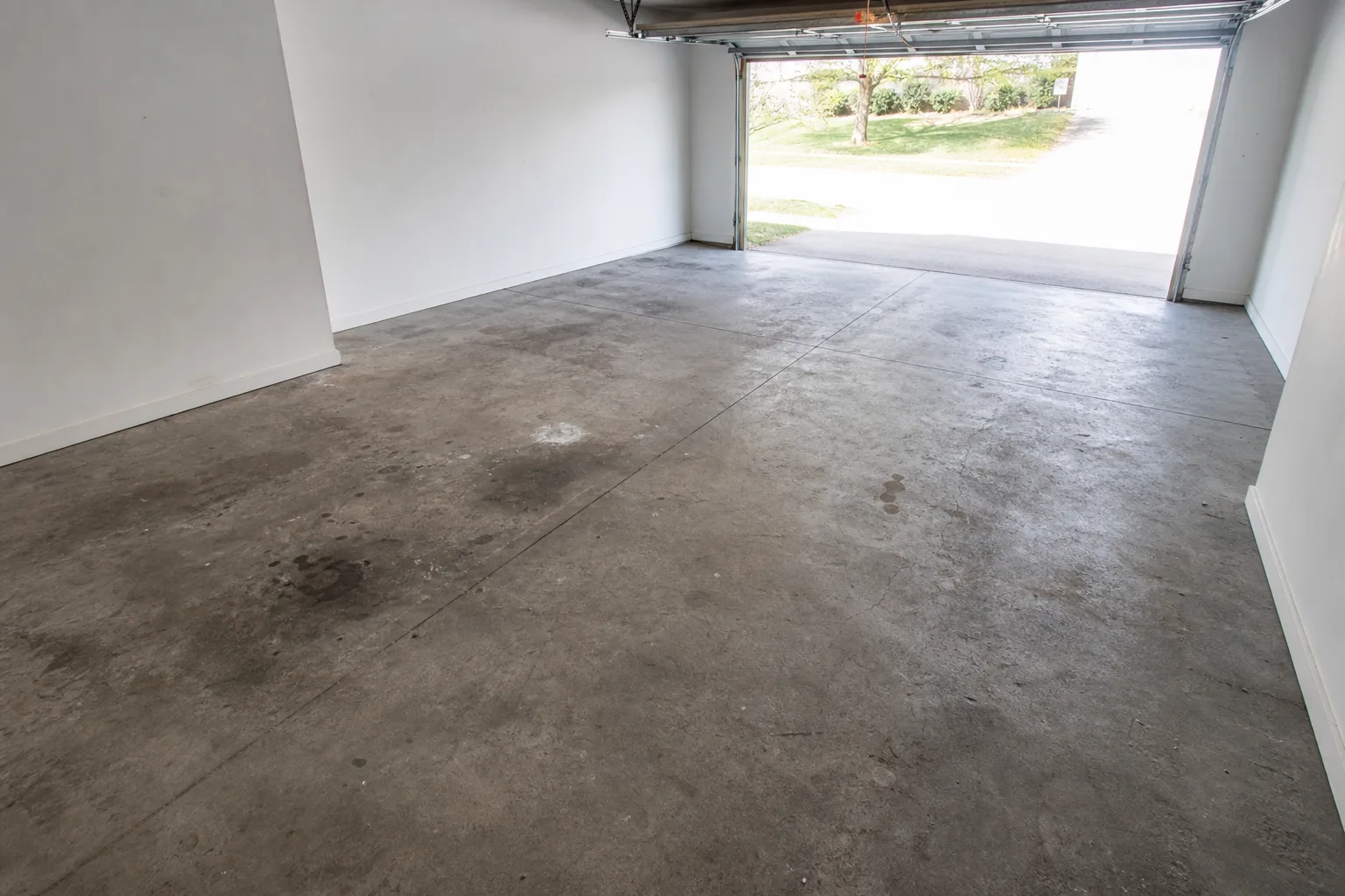 Worn, stained concrete on the left. A professionally prepped and coated floor on the right — same square footage, one to two days of work.